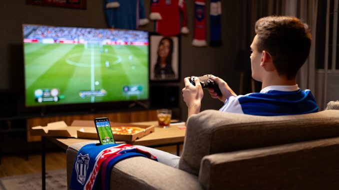 Fan de football jouant aux jeux vidéos